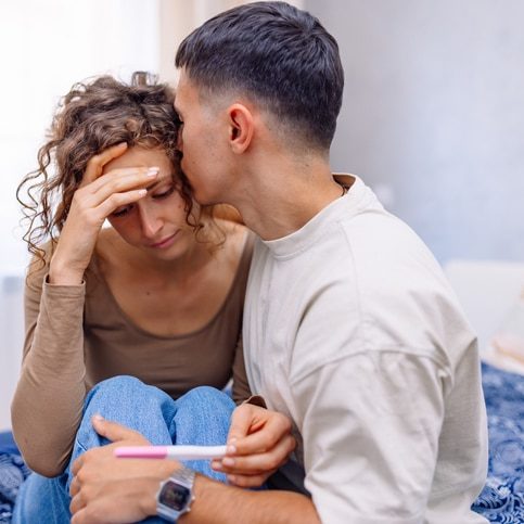 Better Luck Next Month A young Caucasian woman feeling sad and disappointed because of the negative pregnancy test and her partner is trying to comfort her